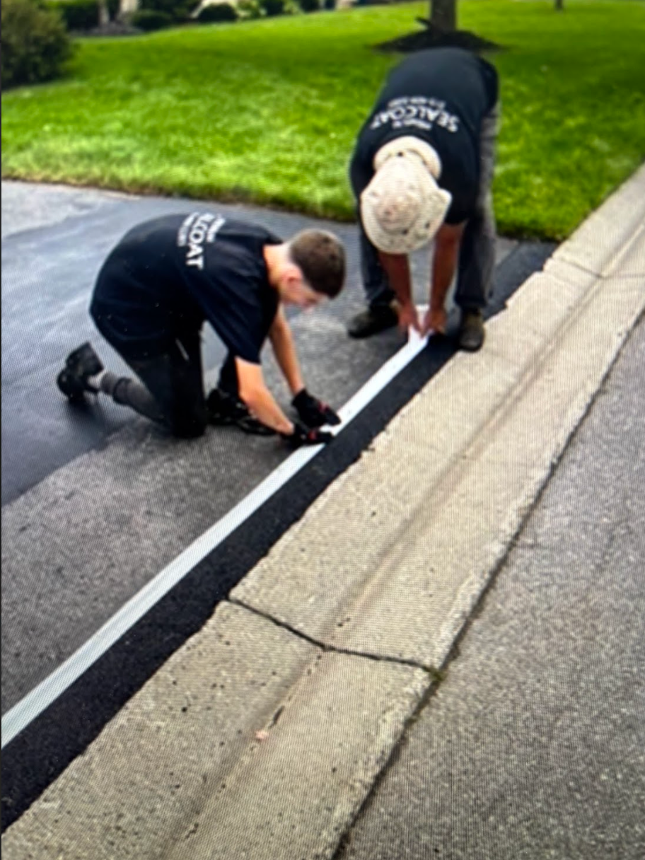 Two men are kneeling down on the side of a road