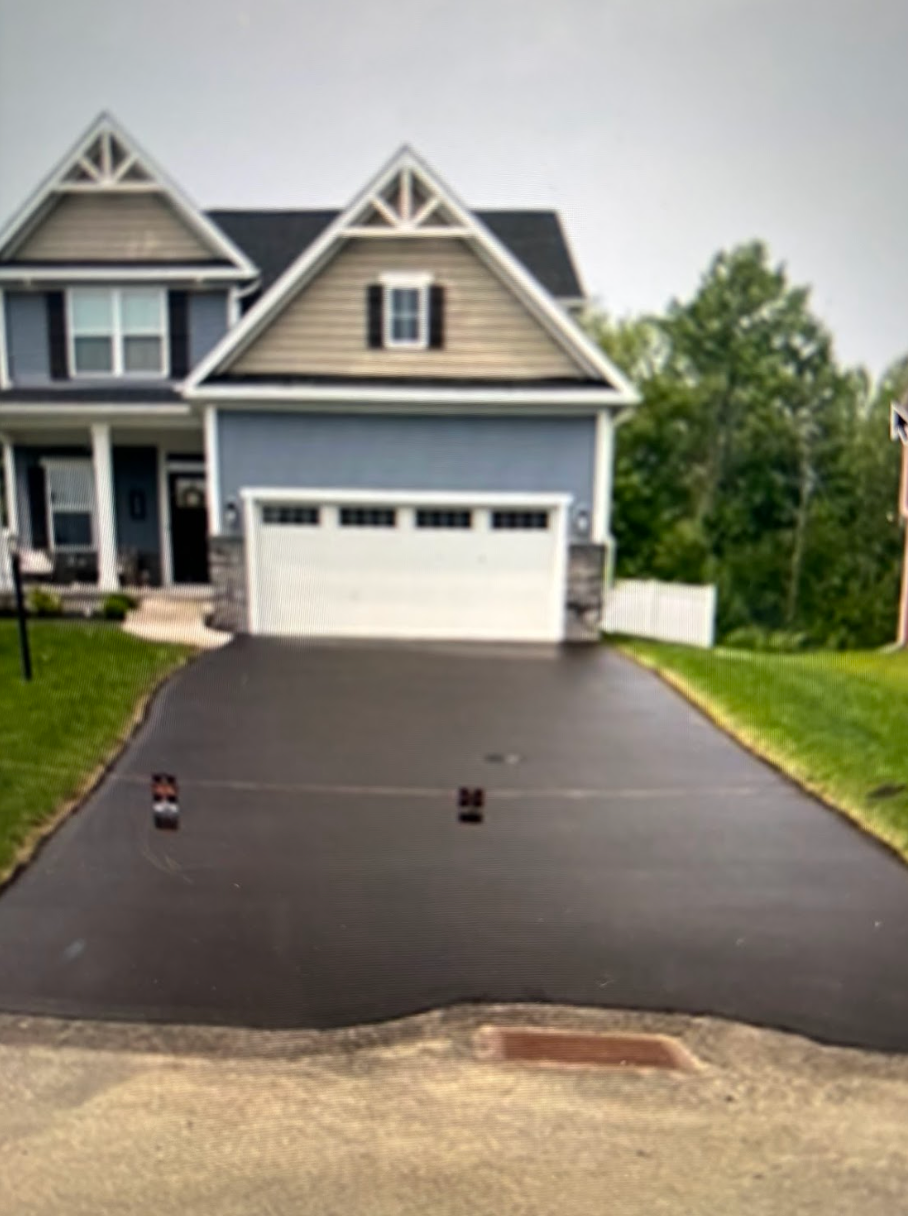 A large house with a black driveway in front of it