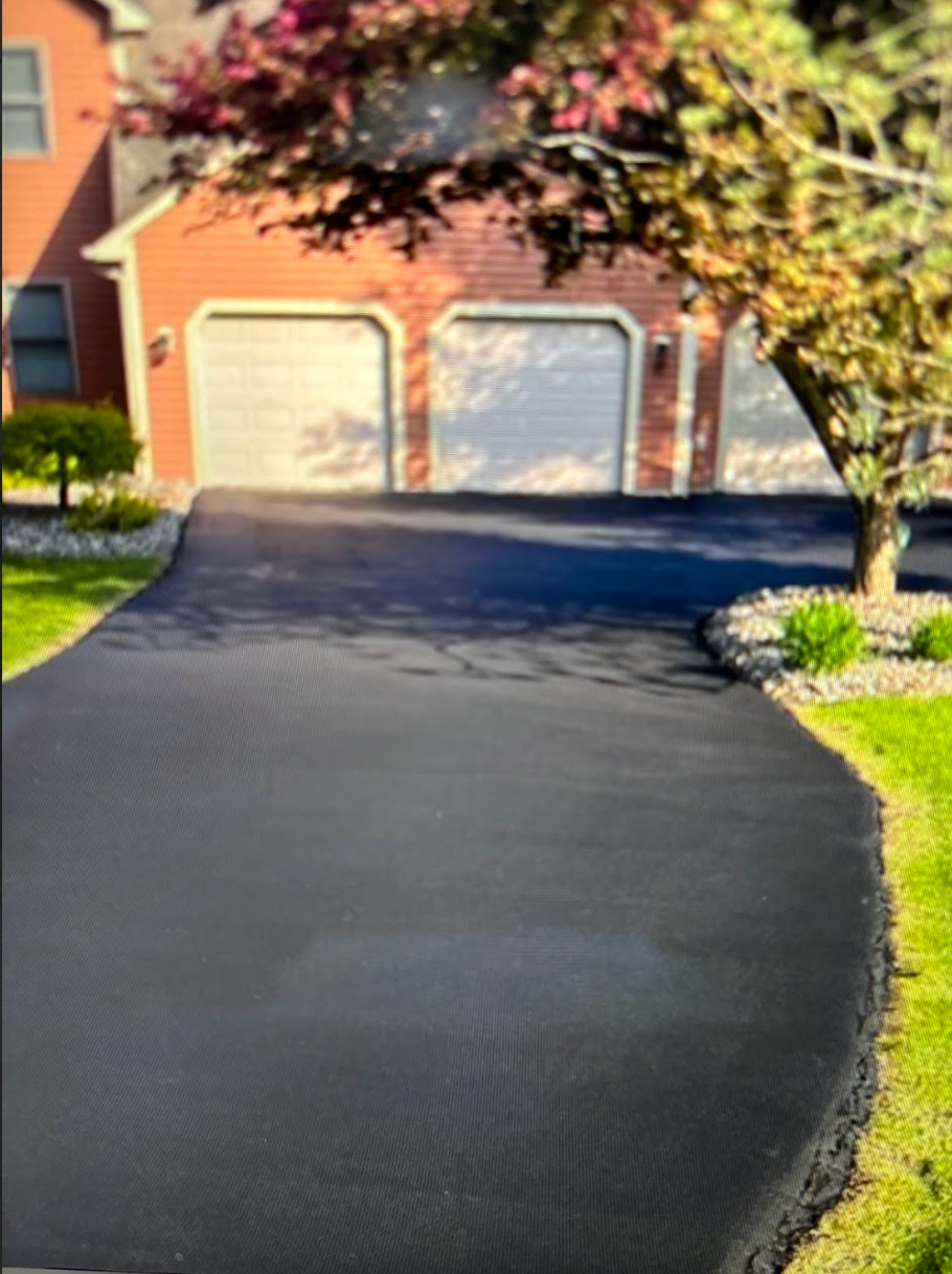 A driveway leading to a house with two garage doors
