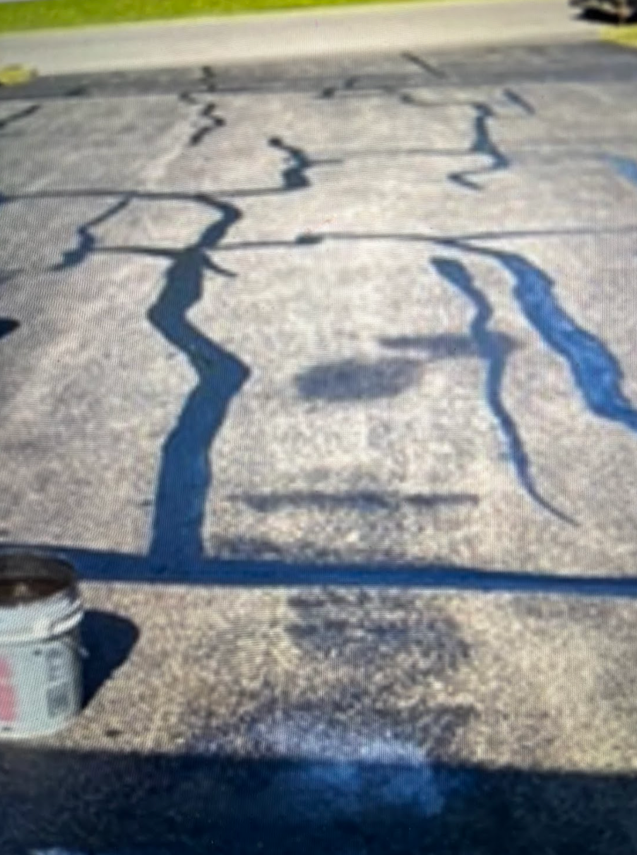A bucket of blue paint is sitting on a concrete surface.