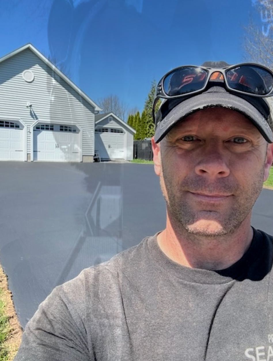 A man wearing sunglasses and a hat is taking a selfie.