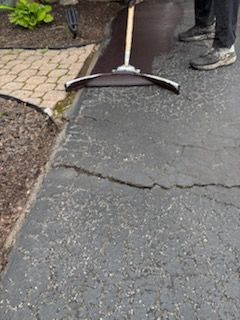 A person is sweeping the ground with a broom.