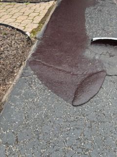 A puddle of water on the side of a road.