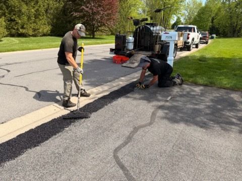 Two men are working on the side of a road.