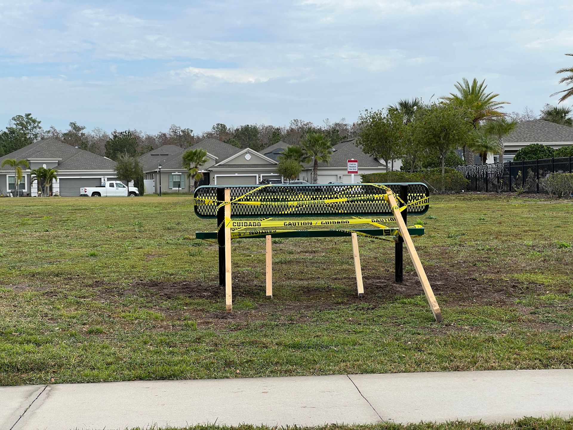 a park bench is sitting in the middle of a grassy field .