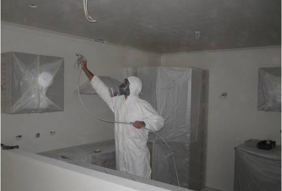 Wayne Webb Painter airless spray painting ceiling and walls in a residential house in Northland