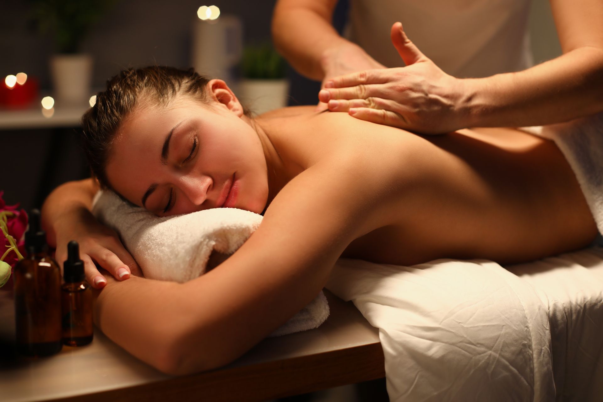A woman is getting a massage on a table in a room.