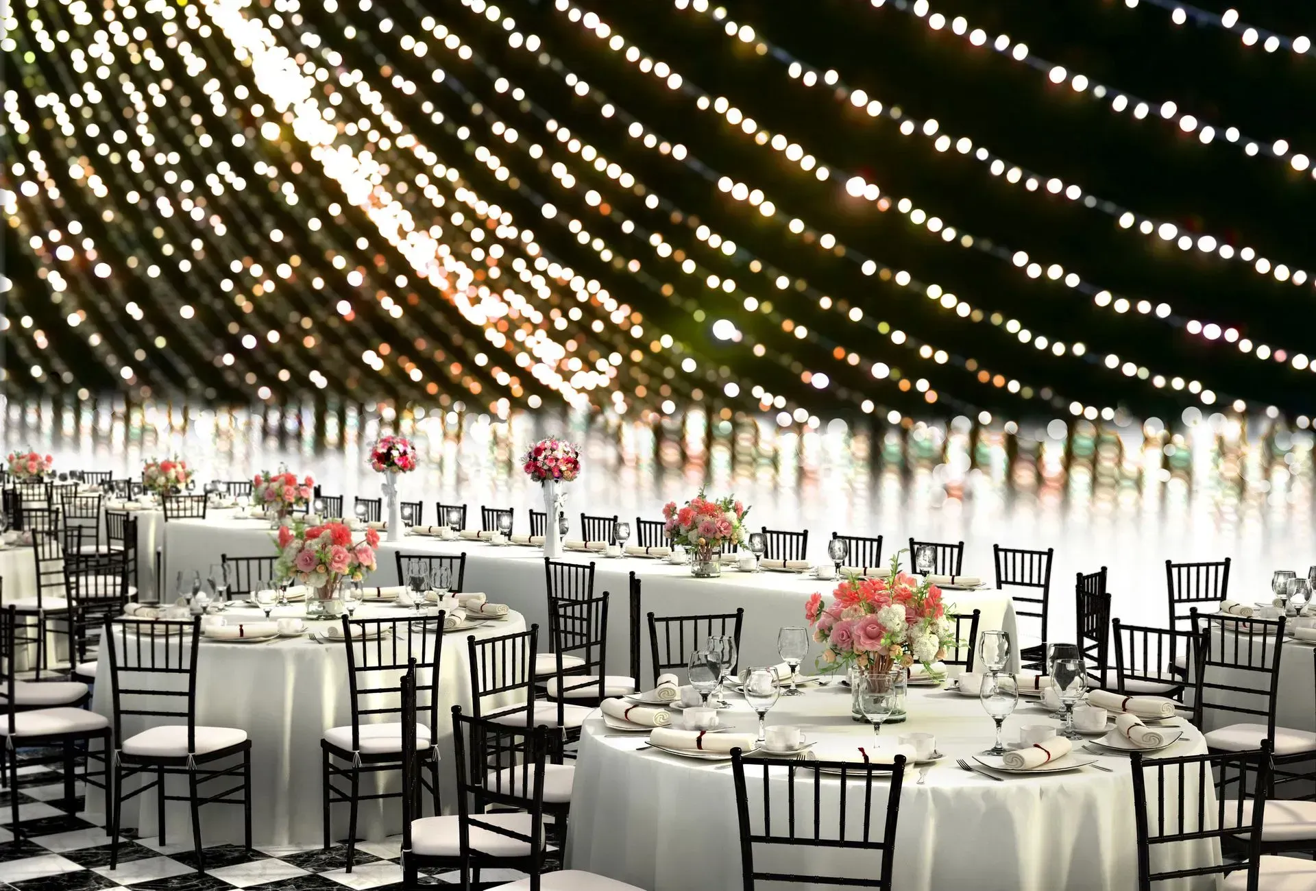 A large room with tables and chairs set up for a wedding reception.