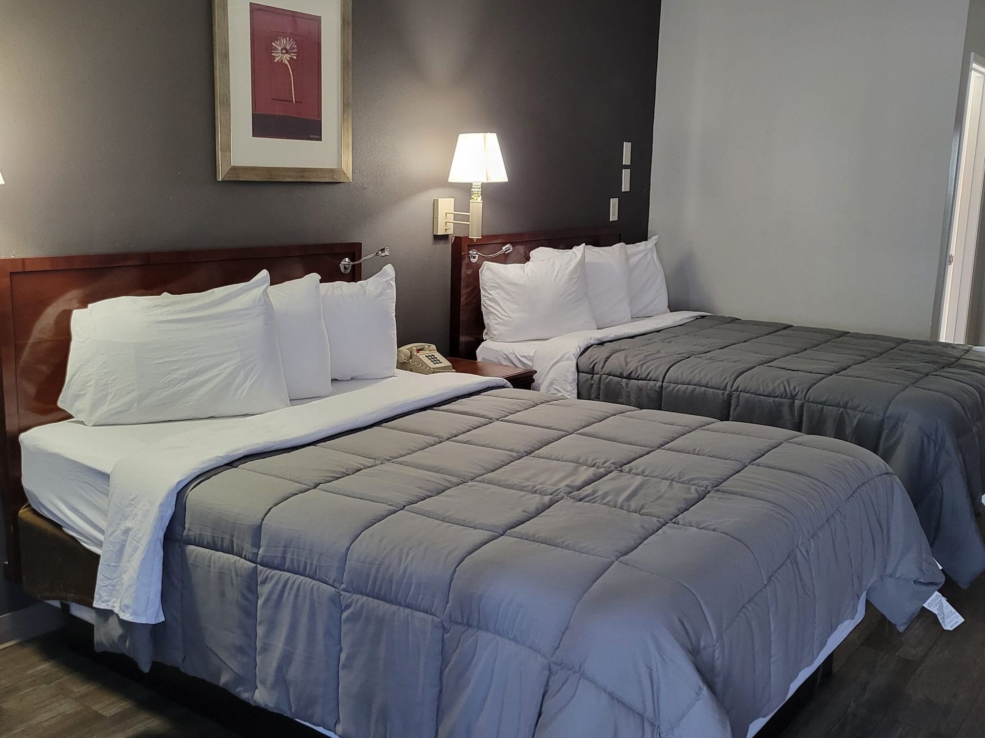 A hotel room with two beds and a lamp