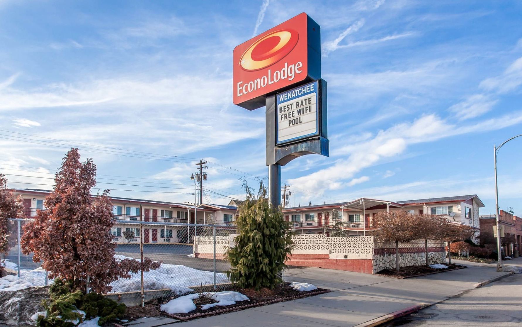 A large sign for a hotel is sitting on the side of the road.
