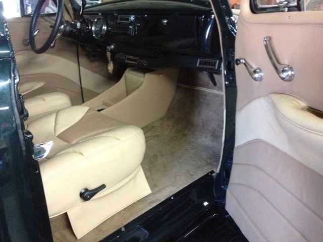 A black car with tan seats and a steering wheel