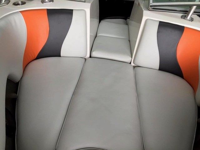 The inside of a boat with orange and gray seats