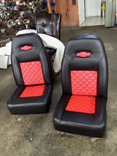 A pair of black and red seats with a chevrolet logo on them