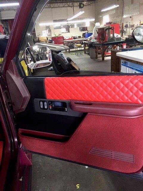 A purple car with red door panels and a mirror