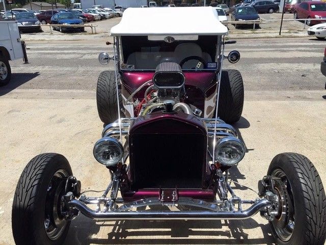 A purple car with a white top is parked in a parking lot