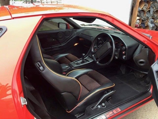 The inside of a red sports car with the door open