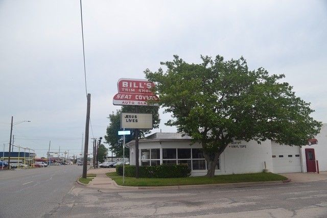 A white building with a red sign that says bill 's