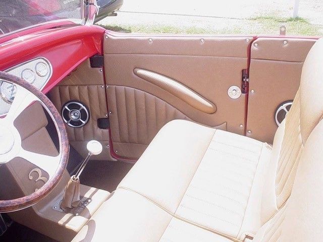 A red car with tan seats and a steering wheel