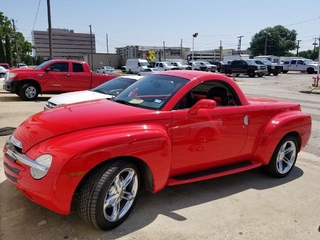 A red pickup truck is parked in a parking lot