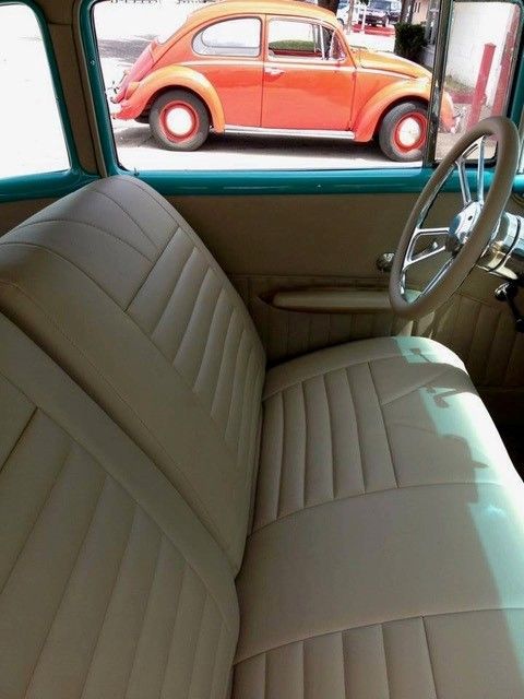 An orange car is parked behind a white car