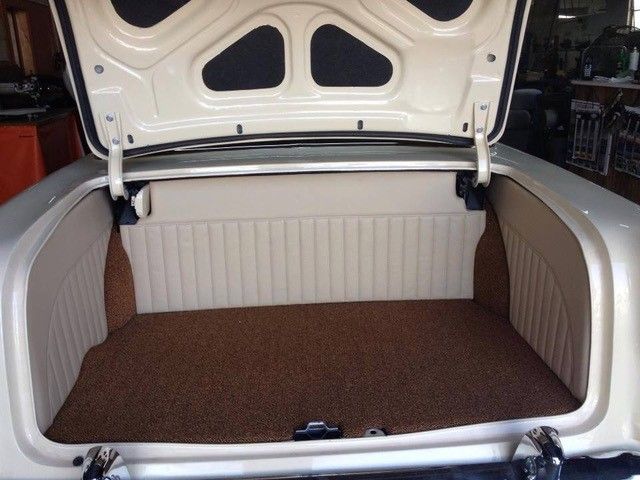 The trunk of a white car with the hood up