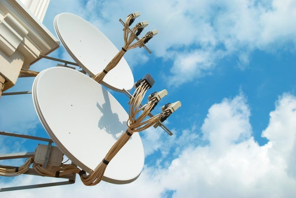 Two White Satellite Dishes Mounted on a Building — Jendata In Northward, QLD