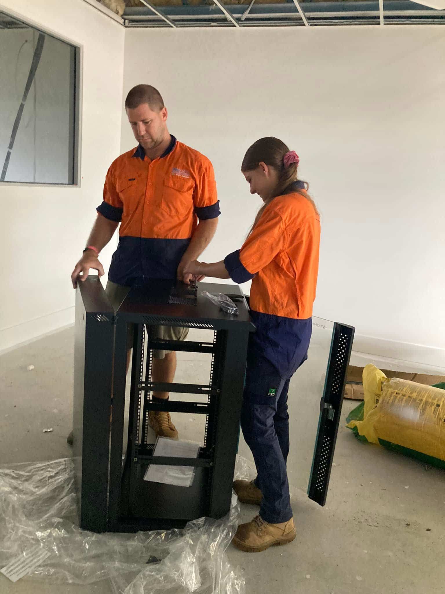 Two Workers Assembling a Dark Metal Structure — Jendata In Garbutt, QLD