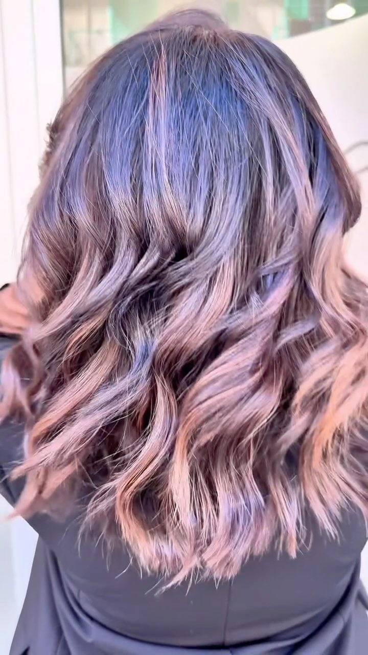 Un primo piano dei capelli di una donna con riflessi viola.