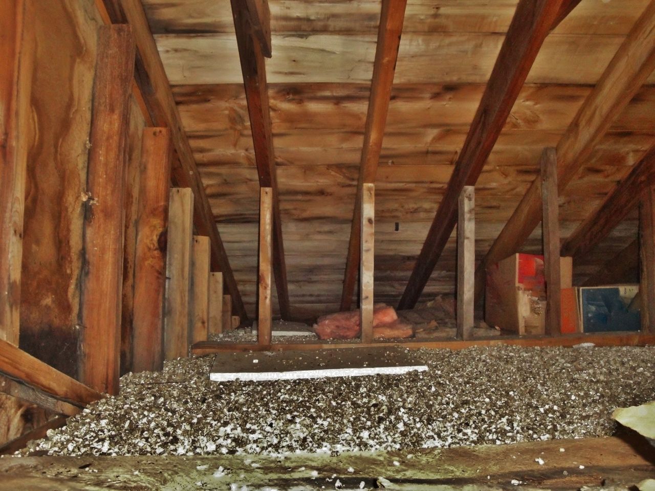 A wooden attic with a measuring tape on the floor