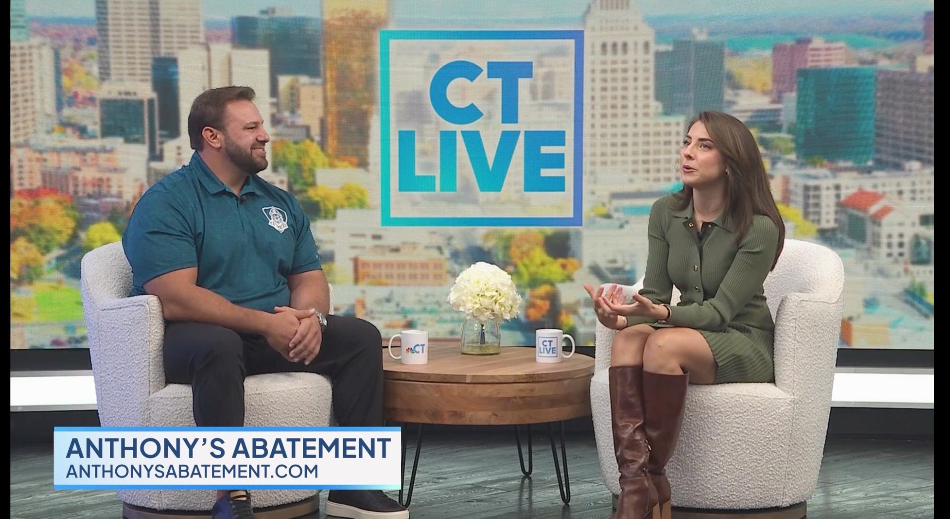 Two people on a TV set. A woman in a green dress and a man in a teal shirt, sitting in chairs, talking. The CT Live logo is in the background.