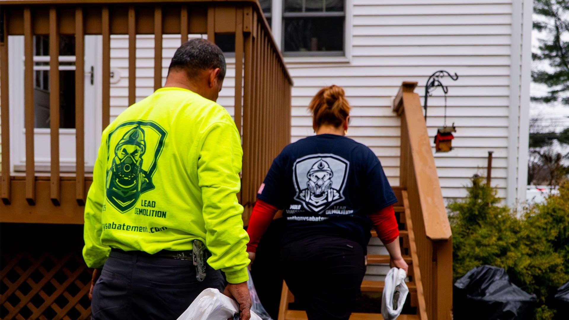 A man and a woman are walking down the stairs of a house.