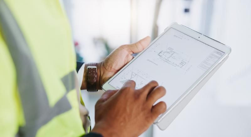 A person reviewing demolition contractor quotes on a tablet, representing the process of requesting free quotes from demolition companies in CT