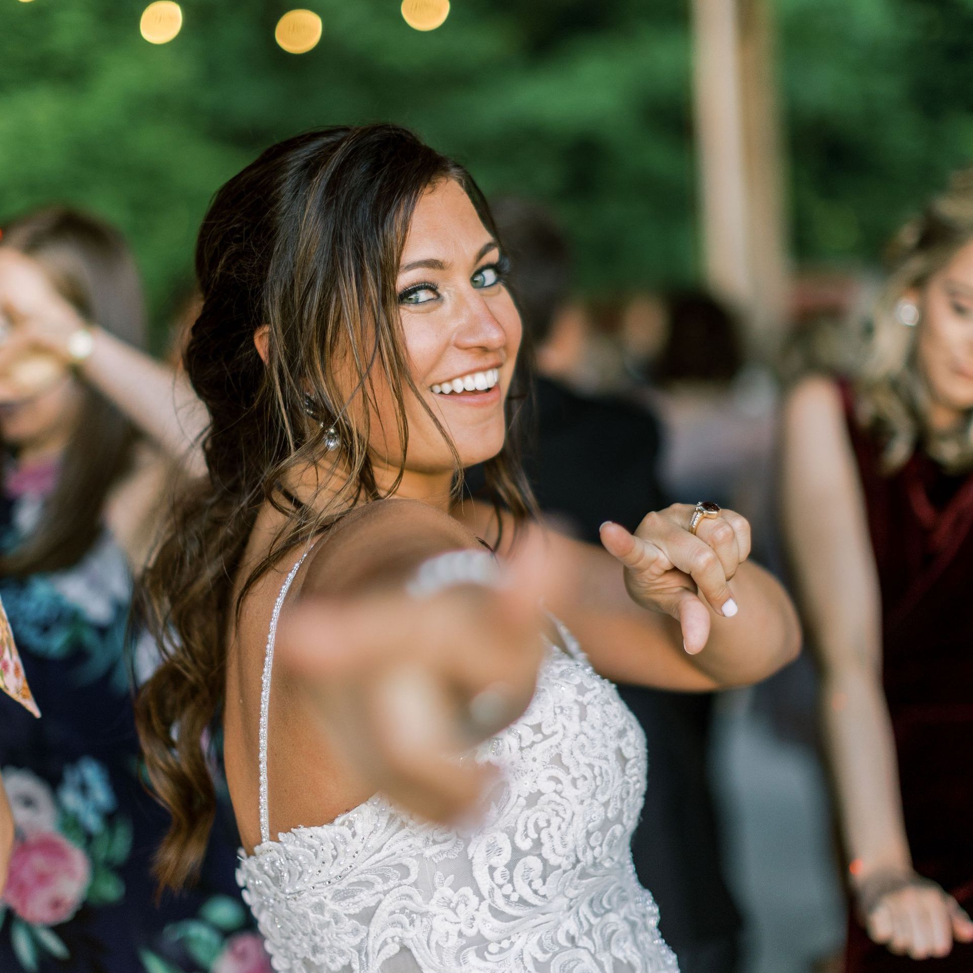 a woman in a wedding dress is dancing and smiling at the camera .