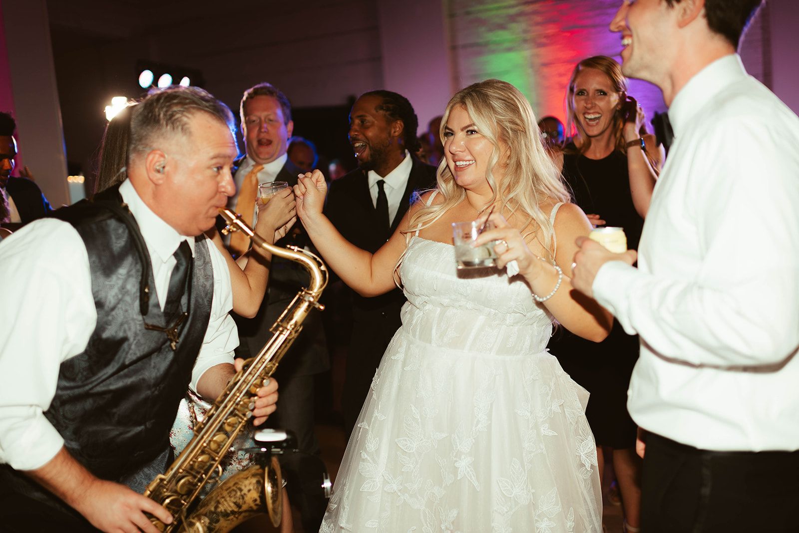 a bride and groom are dancing in front of Mainstreet Soul's saxophone player in Michigan