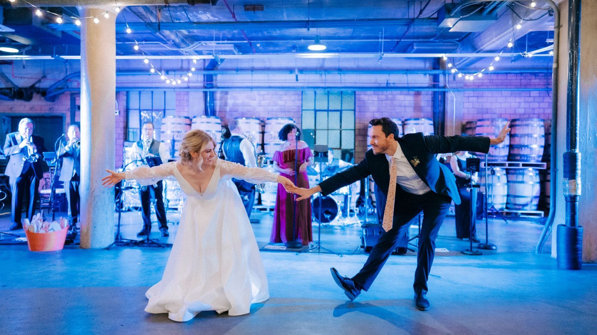 a bride and groom are dancing in front of Main Street Soul in Detroit, Michigan