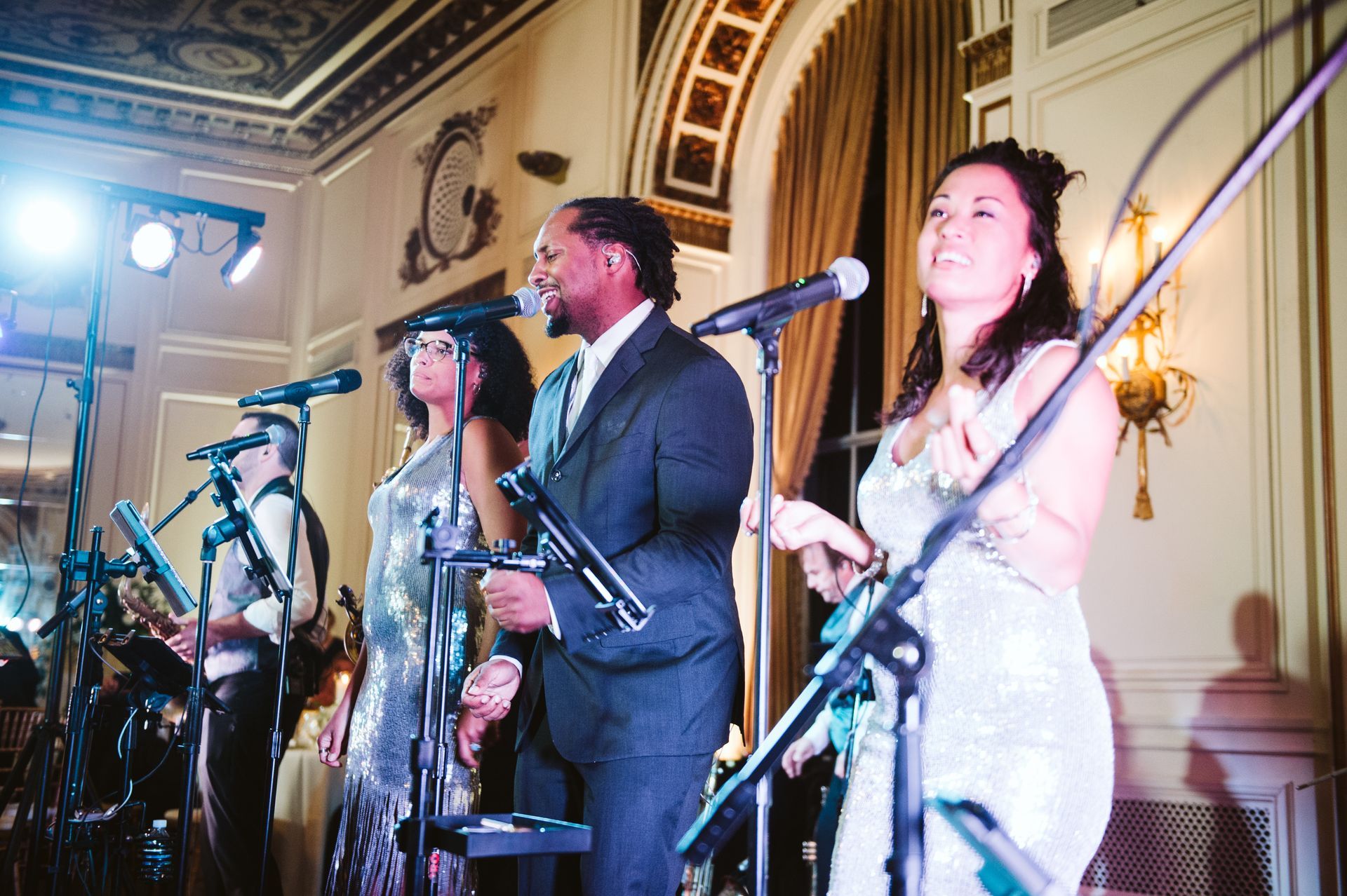Band members from Main Street Soul singing into microphones in a room for wedding in Detroit, Michigan