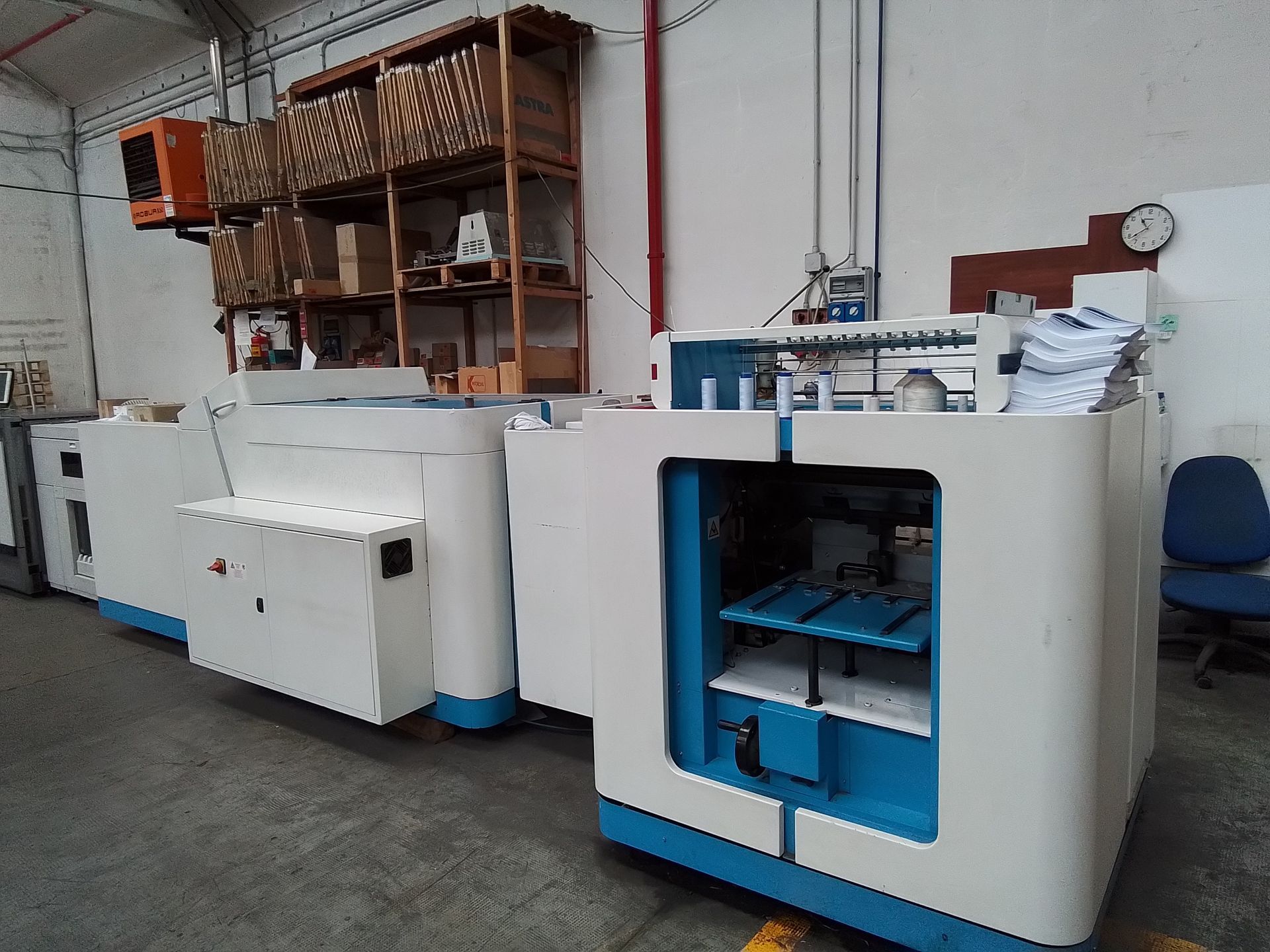 Una macchina bianca e blu è parcheggiata in un magazzino