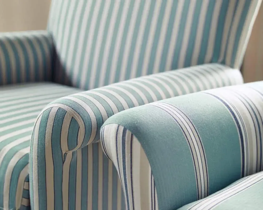 To lænestole med betræk i blågrøn og hvidstribet materiale.