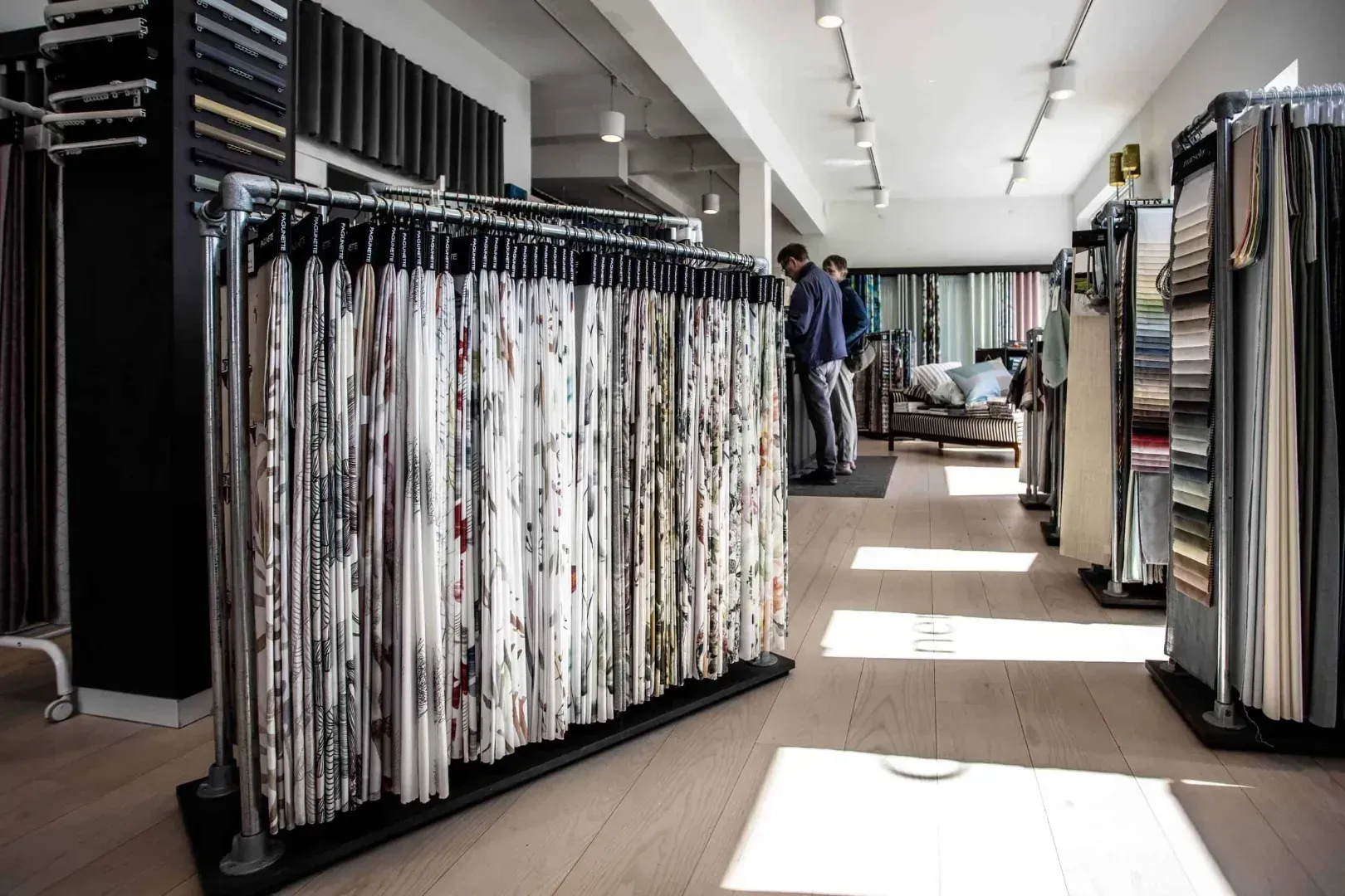 Stofprøver hænger på udstillingsstativer i en butik.