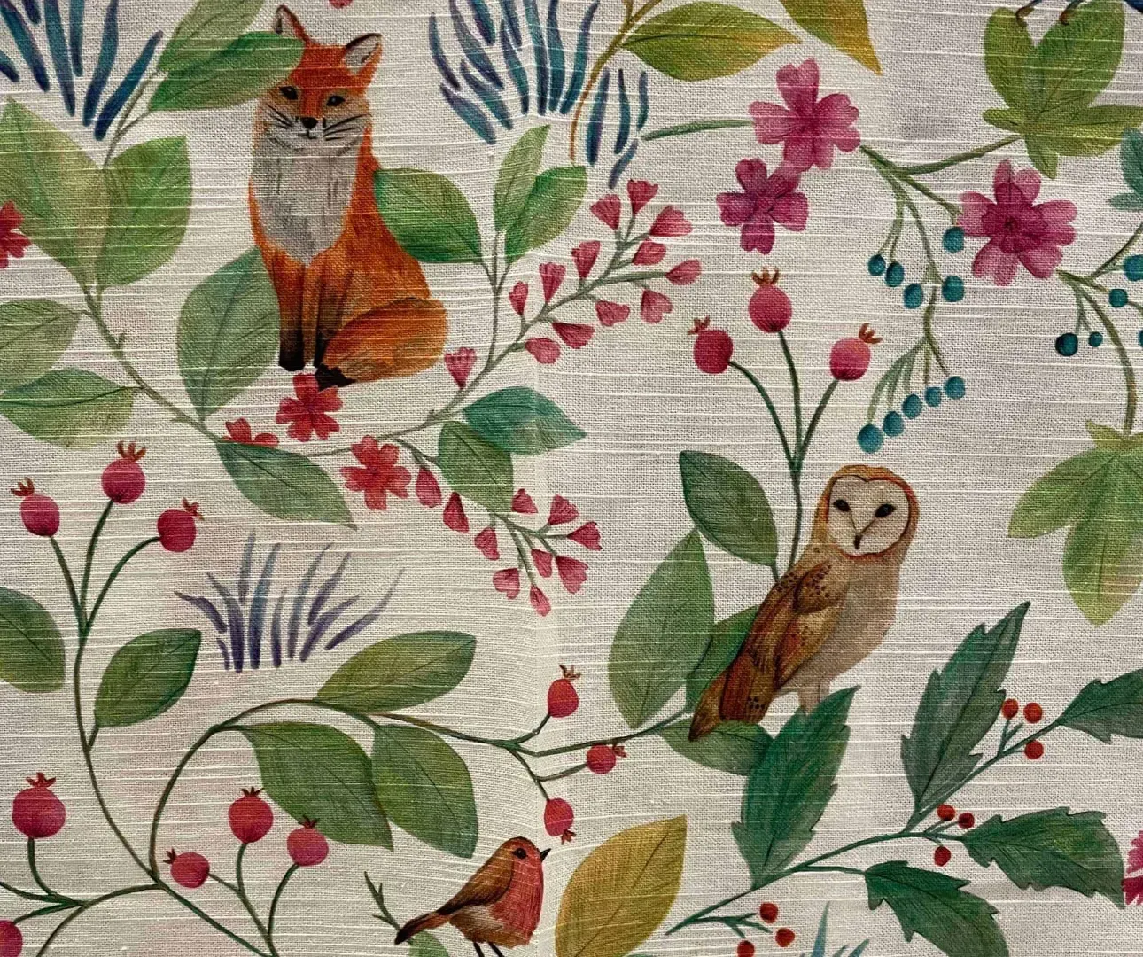 Ræv, ugle og rødhals blandt blomster og bær på en mønstret stofbaggrund.