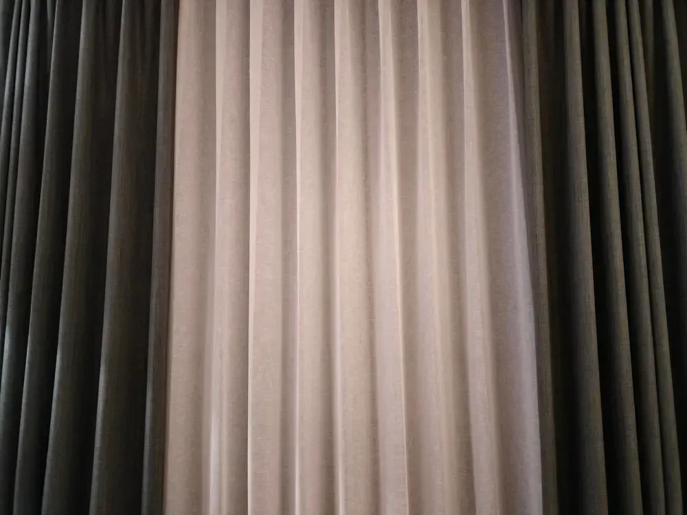 Plissegardiner i grå og beige nuancer.