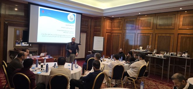 A man is giving a presentation to a group of people in a conference room.