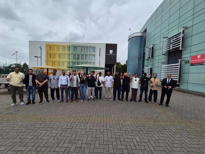 A group of people are posing for a picture in front of a building.