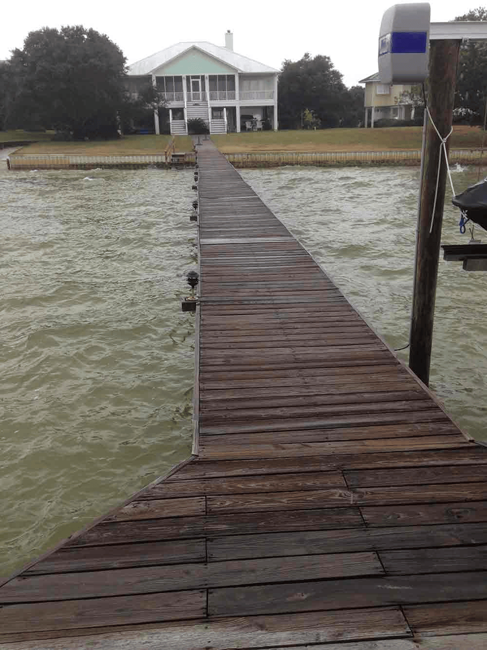 A wooden dock with a house in the background