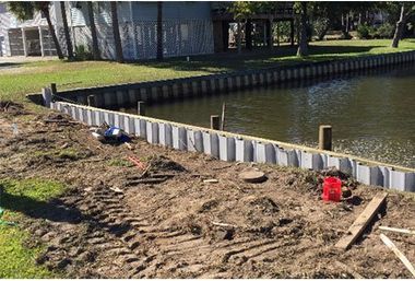 A concrete wall is being built next to a body of water.