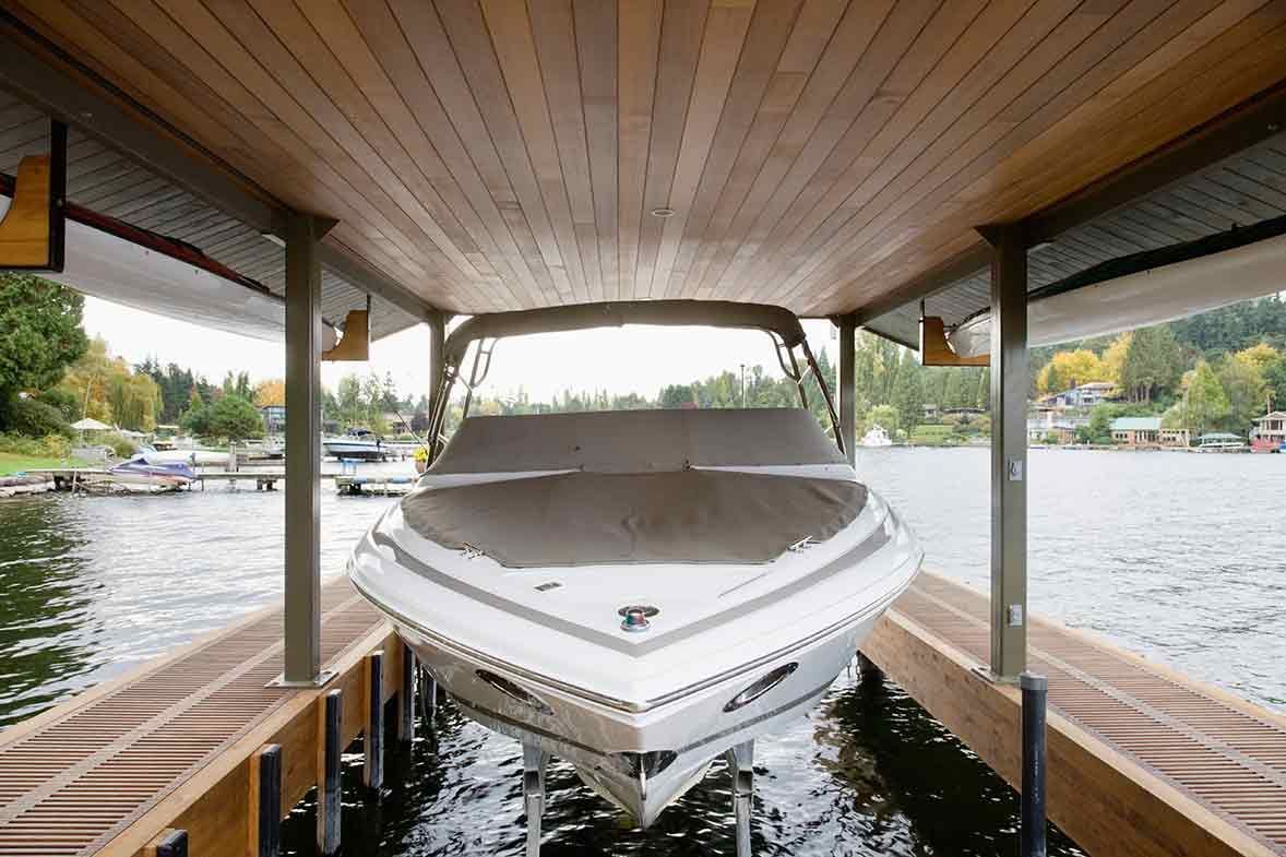 A boat is docked under a wooden structure in the water