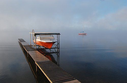 A boat is docked at a dock on a foggy day