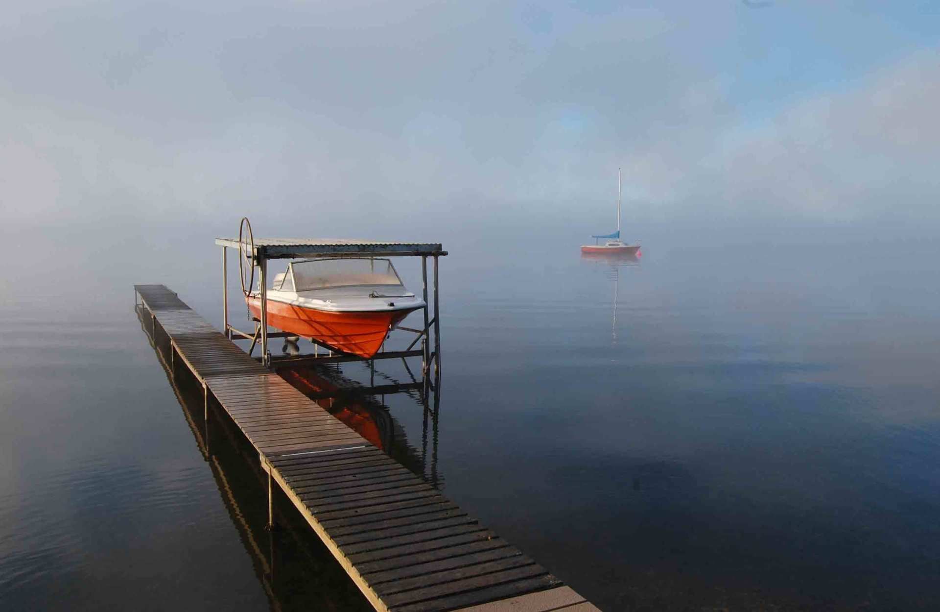 A boat is docked at a dock on a foggy day.