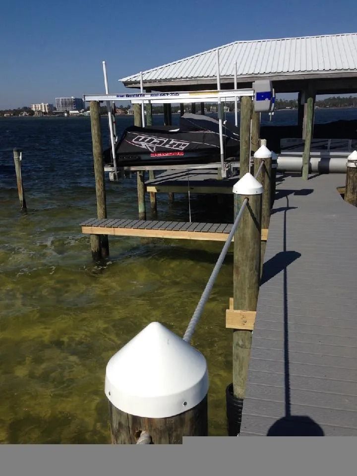 A boat is docked at a dock with a sign that says mercury on it