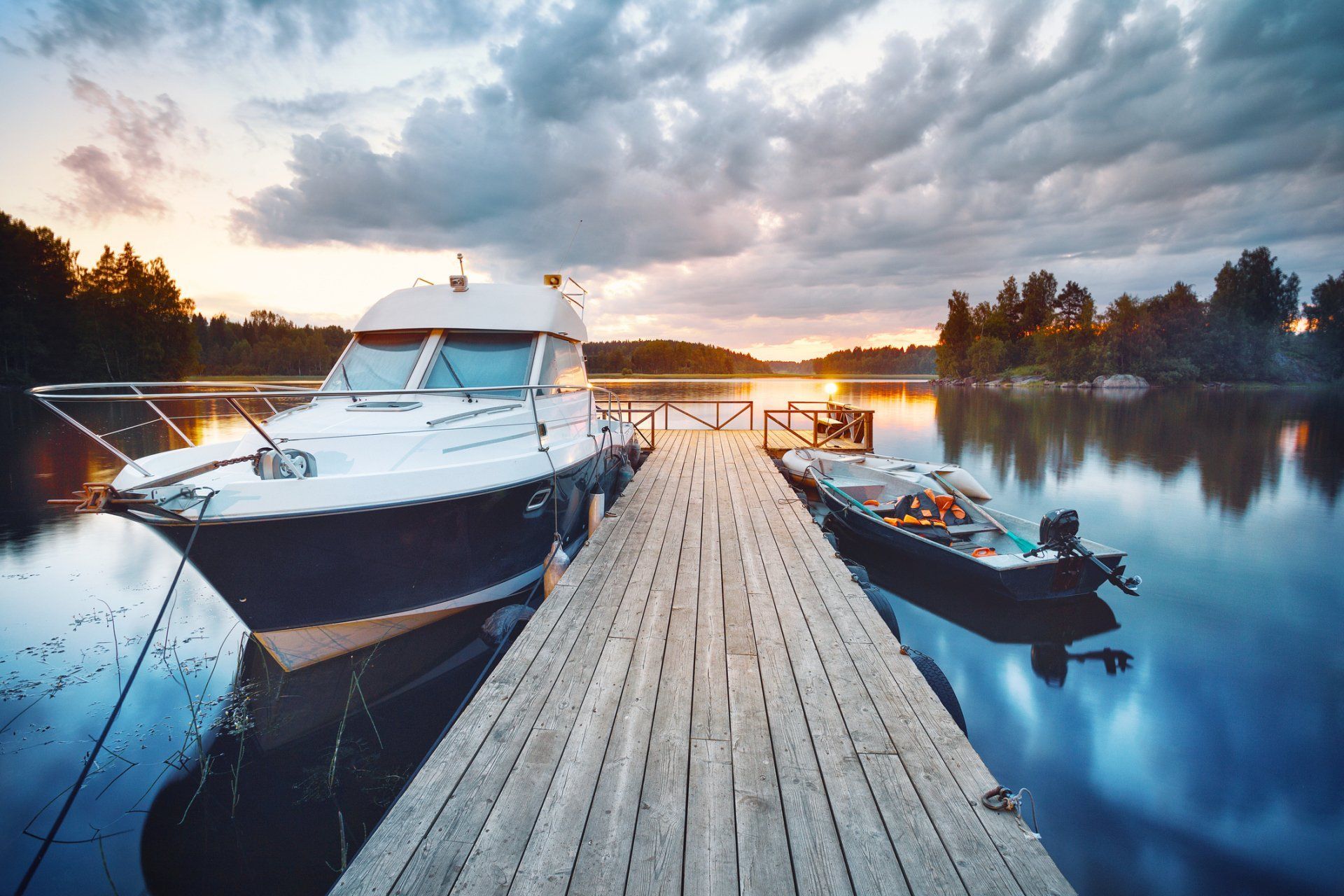 A boat is docked at a wooden dock on a lake.